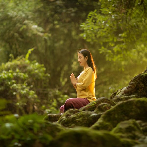 Woman meditating peacefully in a serene environment.